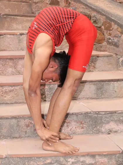 Letting the body relax into a deep forward fold on the steps of this ancient site. Yoga can be practiced anywhere.