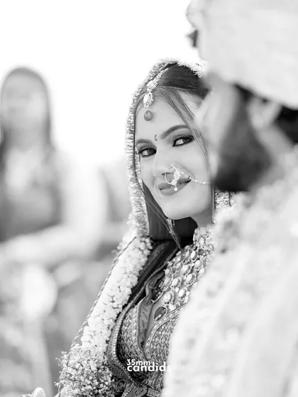 A stolen glance from the bride to her groom during the ceremony. It's a look filled with love, mischief, and the excitement of their new beginning, captured in a beautiful black and white candid.