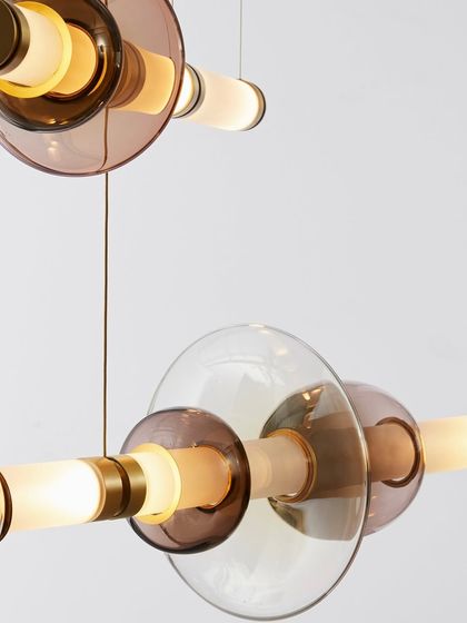 A detailed shot of the Luna series reveals the interplay of colored, transparent, and translucent glass shapes with polished brass hardware. This image emphasizes the rich materials and artisanal quality I select for my collections.