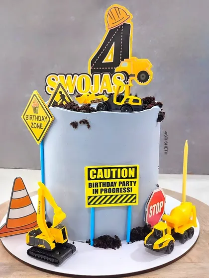 A construction zone birthday cake for a little builder. This White Chocolate Mousse cake is complete with toy trucks, signs, and edible dirt.