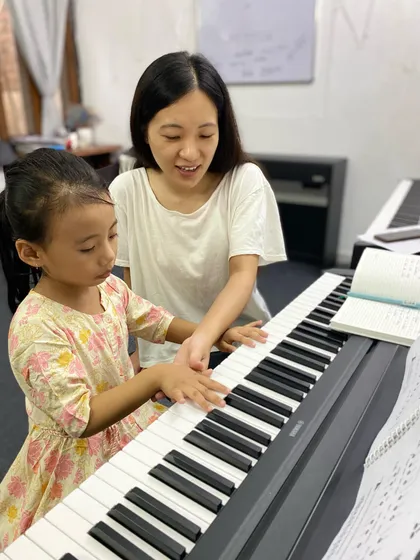 A glimpse into a piano lesson, where our instructor provides one-on-one guidance. We believe passionate teaching is the key to unlocking a student's potential.