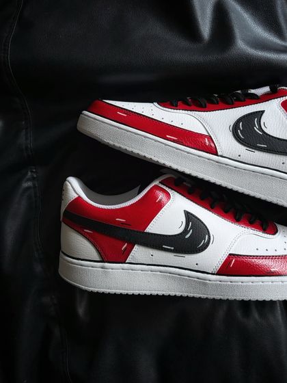 A top-down view of the red cartoon custom sneakers.
