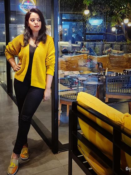 A pop of color with a yellow cardigan over an all-black outfit. This is a great styling trick to brighten up a basic look.