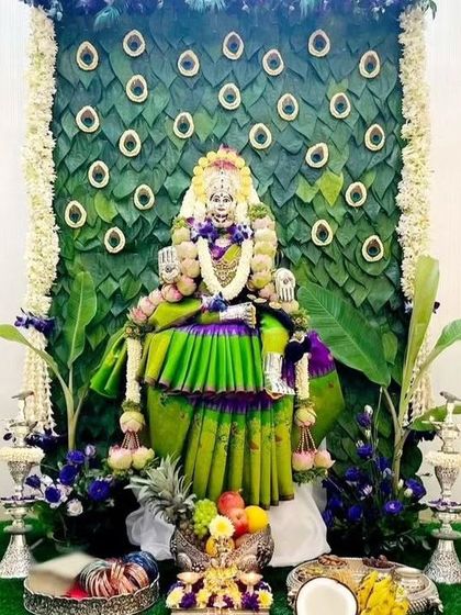 A divine backdrop for a goddess idol, created with a peacock feather motif made from fresh green leaves. This eco-friendly design is both beautiful and symbolic.