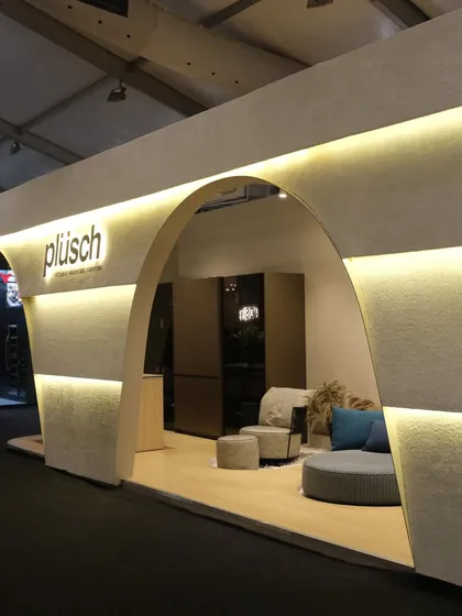 This angle highlights the inviting curve of the main arch and the way it frames the interior display. The design is subtle yet striking, a physical manifestation of the Plüsch brand's ethos.