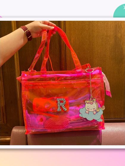 Another look at our double-pocket jelly tote, this time in a vibrant orange-pink, customised with a unicorn charm.