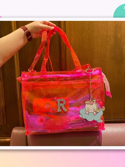 This jelly tote bag is perfect for a pool party or a beach day. It's shown here with a personalised initial and a sleeping unicorn charm.