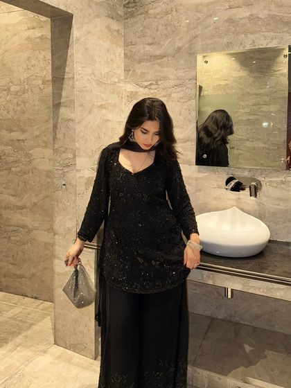 A shot looking down at the black ethnic outfit, which helps to showcase the neckline and the detailed texture of the fabric.