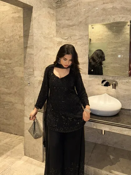 A shot looking down at the black ethnic outfit, which helps to showcase the neckline and the detailed texture of the fabric.