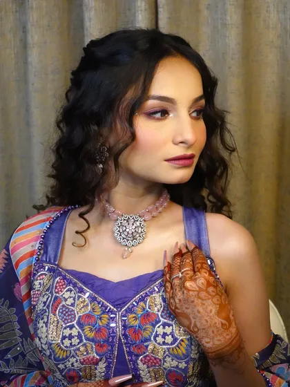 A stunning Haldi and Mehndi look from my makeup masterclass. This style features curly hair, glittery purple eyeshadow, and a bold lip, perfect for a modern bride.