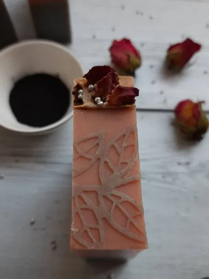 Detail is so important to me. This close-up of my Charcoal Rose soap shows the delicate leaf pattern I stamp by hand, topped with real dried rose petals for a touch of luxury.