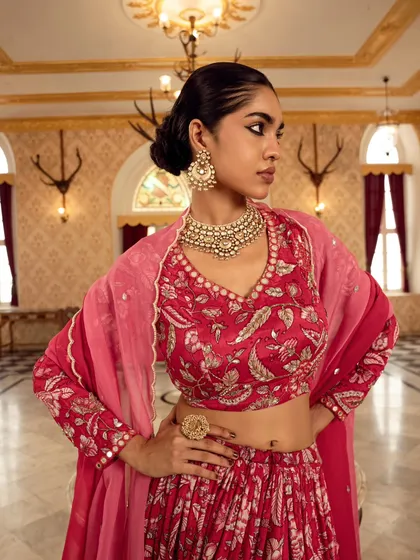 A close-up profile shot emphasizing the intricate jewelry and blouse detailing of a bridal ensemble. The composition draws attention to the craftsmanship of the entire look.