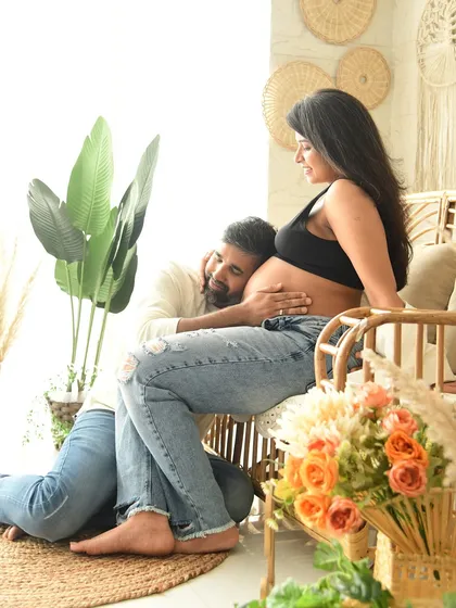 A tender pose where the father-to-be listens to the baby bump. Set in our warm, naturally-styled boho corner, this image is filled with love and anticipation.
