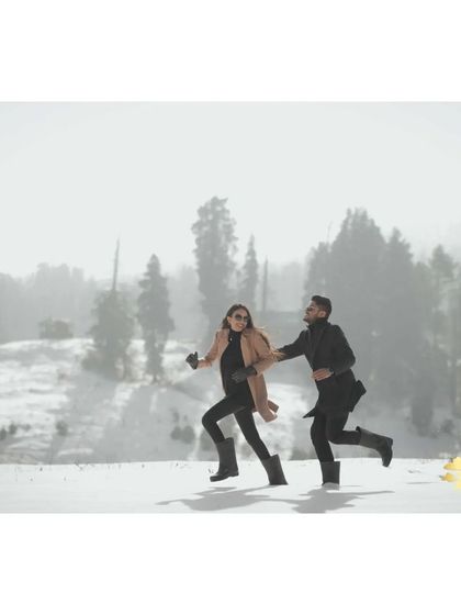 A fun, action shot of the couple running and laughing in the snow in Kashmir. This photo is full of energy and shows the playful side of their relationship.