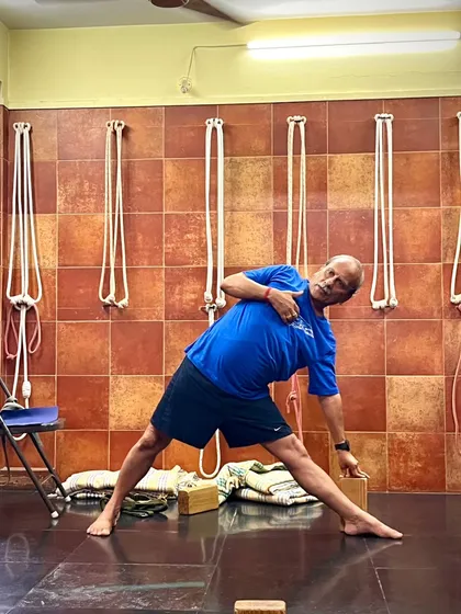Using a block and the wall ropes in Utthita Trikonasana (Triangle Pose). The block helps to keep the chest open, while the ropes provide traction and support for the spine.
