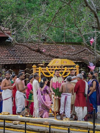 A wide shot of a wedding ceremony taking place at the Pond Pavilion, with guests seated on the steps of the Kalyani.