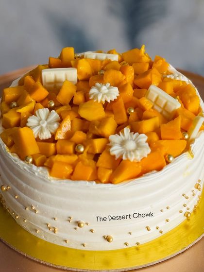 My Mango Maharaja cake, decorated with white chocolate bars and edible flowers. Every bite is filled with the taste of summer, making it a seasonal best-seller.