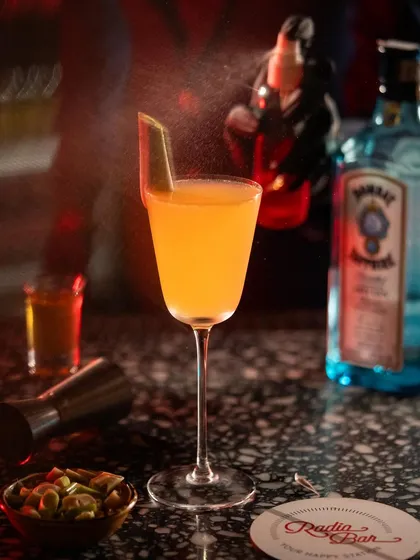 An orange cocktail with a spritz of zest. The motion of the spray adds a dynamic element to this classic bar shot.