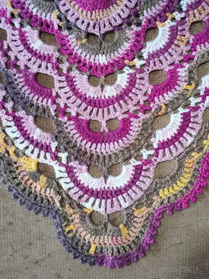 A close-up of the iconic fan-like pattern of the Virus Shawl. This design is a great way to practice increasing stitches to create the growing triangular shape.