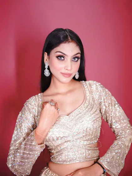 A close-up that captures the glamorous eye makeup and the sparkle of the outfit.