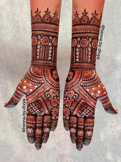 A traditional full-hand mehendi design with symmetrical patterns. The geometric and floral elements are densely packed, creating a classic and timeless look.