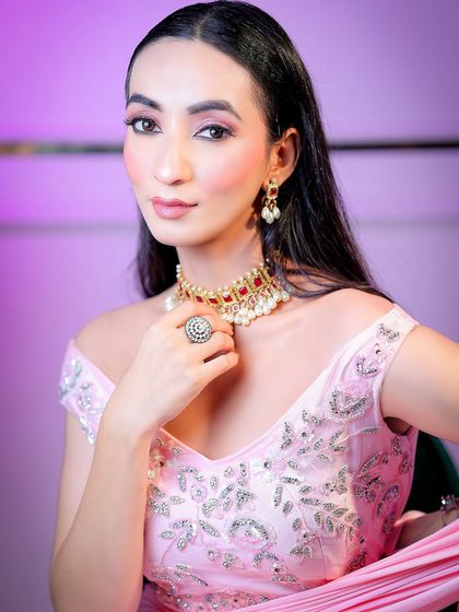 A direct and engaging portrait that highlights the model's features and the soft, elegant makeup.