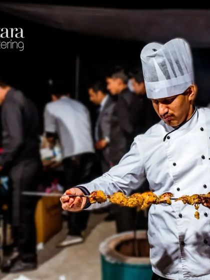 A dedicated chef pulling a freshly cooked skewer from the tandoor. Our team works tirelessly to ensure every event is flawless and memorable.