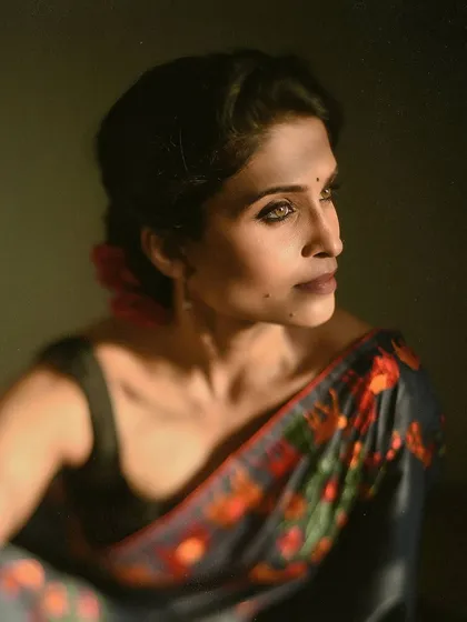 This is a more dramatic take on the saree portrait, using shadows to create mood and depth. The low-key lighting creates a sense of intimacy and introspection, focusing on the model's thoughtful expression.
