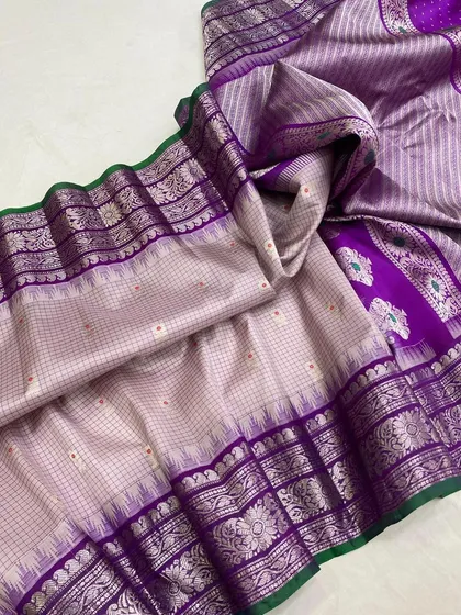 A stunning saree in a light grey with a purple and silver border. The intricate silver zari work gives it a very sophisticated and modern feel.