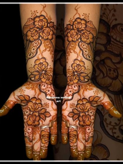 An elegant floral design featuring delicate birds perched among the flowers. The fine lines and graceful composition give this mehendi a light and airy feel.
