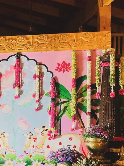 A detail of the custom-painted Pichwai backdrop. The artwork, featuring lotus ponds and cows, adds a beautiful, artistic, and spiritual dimension to the naming ceremony decor.