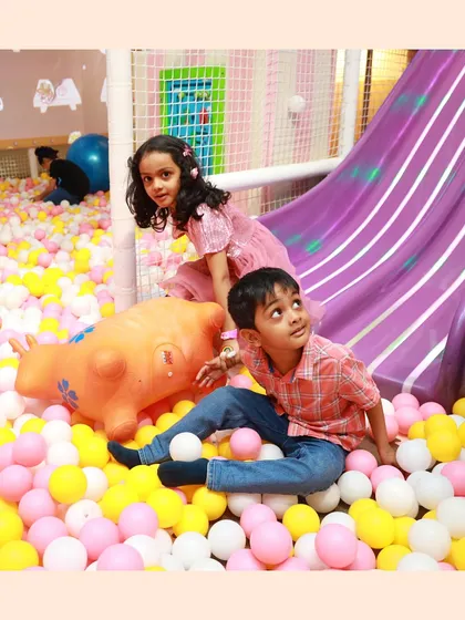 Friends enjoying the ball pit together after a trip down the slide. It's the perfect soft landing spot.