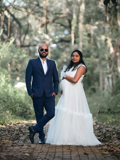 A cool and confident couple's maternity photo. The classic white ruffled gown provides a beautiful contrast to the partner's sharp suit.