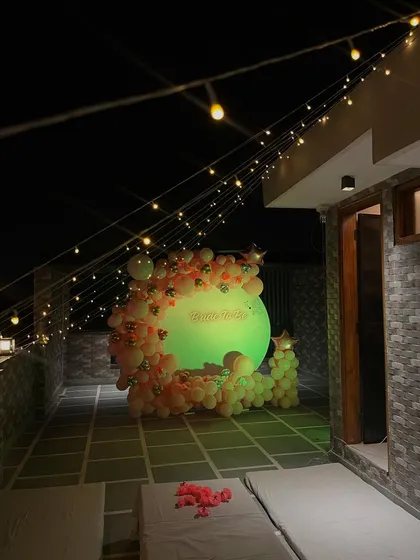 The terrace setup at night, with the 'Bride to be' backdrop glowing under the string lights.