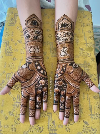 An elegant engagement mehendi featuring the couple's initials 'SR' and intertwined wedding rings. It's a perfect way to celebrate the start of a new journey together.