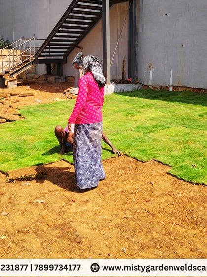 Our team members carefully placing and fitting the turf squares together to create a uniform lawn surface.