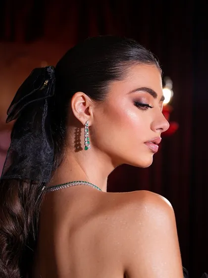 The side profile highlights the beautiful glow on the skin and the soft, romantic ponytail.