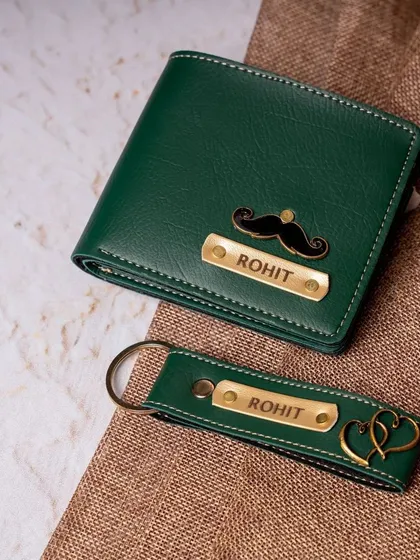 This matching vegan leather wallet and keychain set is a classic gift for him. Both items are personalized with the same name and charm for a coordinated look, shown here in a stylish dark green.
