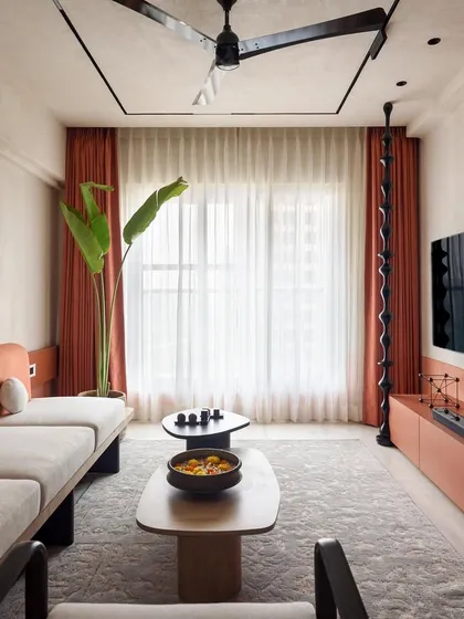 For our project 'A Den', we blended modern design with the client's South Indian heritage. This living room uses an earthy terracotta and neutral palette, with custom furniture and a large banana plant to bring nature indoors. It shows our ability to create a home that feels both contemporary and deeply personal.