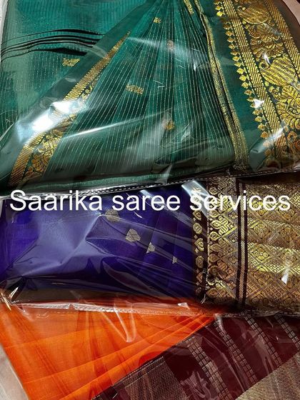 Three sarees in green, blue, and orange, all packed and ready. This is a great way to organize your wardrobe by color.