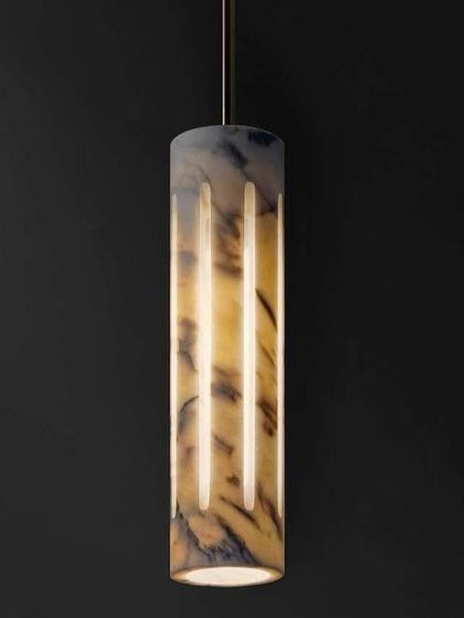 A cylindrical pendant made from a darker, dramatically veined marble. This piece makes a bold statement while still feeling natural and elegant.