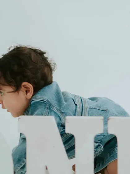 A side profile as he crawls past the 'ONE' letters. This angle provides a different perspective and highlights his baby features.