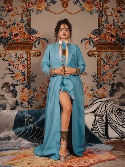 The first look from the same celebrity editorial, featuring a more structured, androgynous style. The makeup is strong and defined, with an emphasis on the eyes and brows.