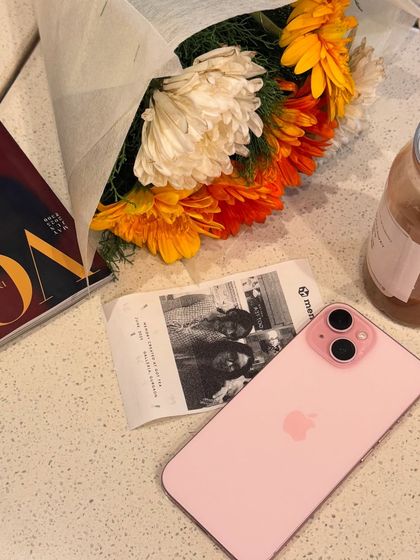Another aesthetic flat-lay. A bouquet of flowers, a photobooth strip, and my pink iPhone create a snapshot of a perfect day, ideal for content that feels personal and curated.