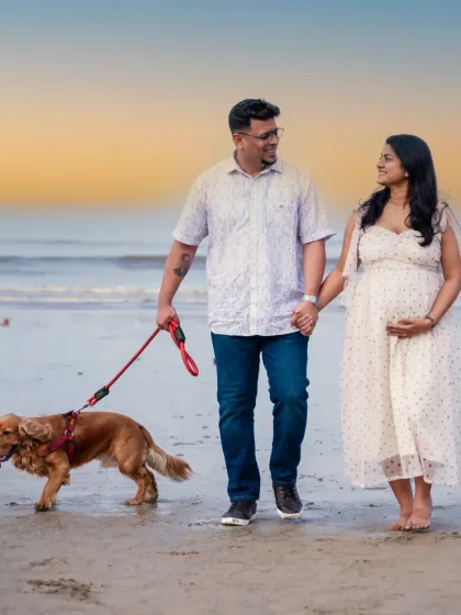 The whole family, including their furry best friend, enjoying a walk on the beach at sunset. A perfect, warm, and loving maternity portrait.