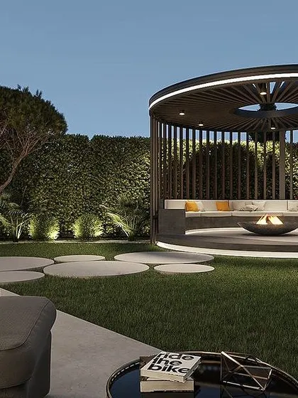 For this project, we designed a unique circular gazebo with built-in seating and a central fire pit, creating a cozy and modern focal point for the garden. The surrounding landscape features ambient lighting and manicured greenery, perfect for evening gatherings.