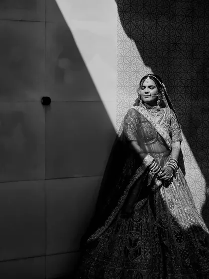 We love playing with light and shadow to create artistic bridal portraits. Here, a single beam of light illuminates the bride, Aneri, creating a dramatic and elegant black and white image.