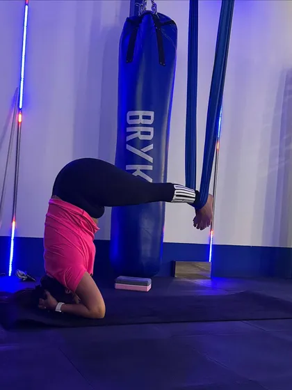 A supported headstand variation, where the hammock holds the legs. This allows you to work on alignment and core engagement without bearing full body weight.