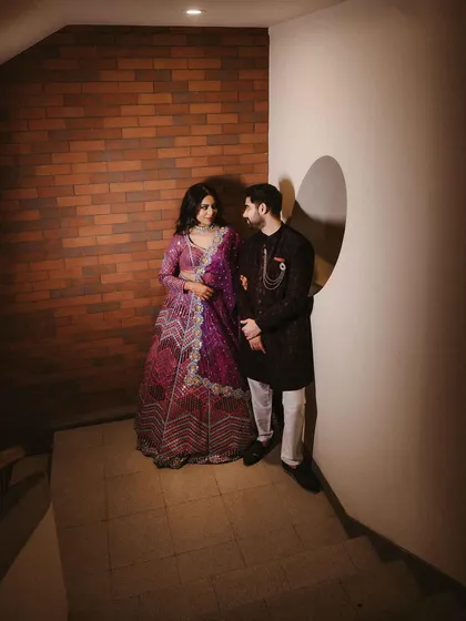 A full-length portrait of Aishwarya and Archit in a modern, minimalist corner. The unique lighting and architecture create a moody and stylish frame for the couple.