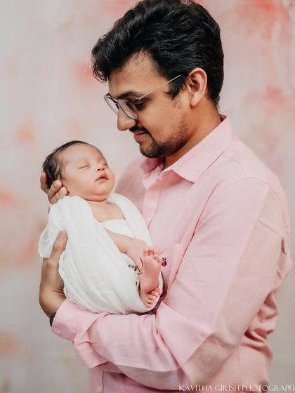 A father's gentle gaze at his sleeping newborn. These simple, emotional portraits highlight the profound connection between a parent and their child.